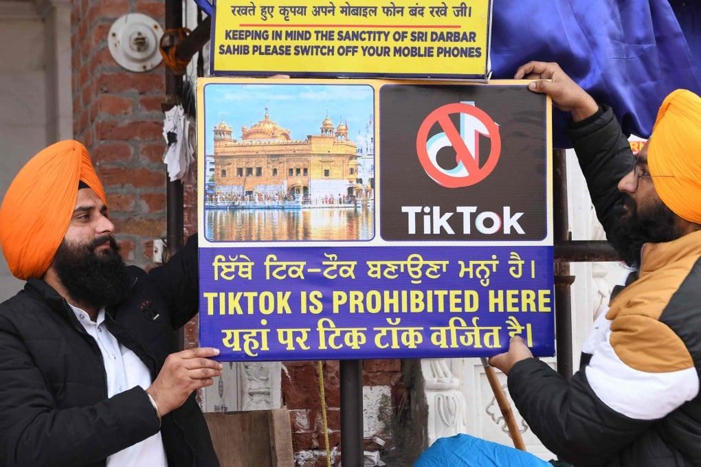 Sikh volunteers hang a sign reading ‘Tiktok is prohibited here’, at the Golden Temple in Amritsar. Photo: AFP/File
