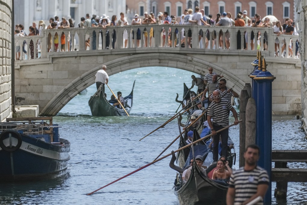 Gondoliers proceed slowly near the crowded Sospiri Bridge close to St Mark’s Square in Venice because of heavy water traffic. The city this week began charging day-trippers for entry, the latest measure by a European tourist destination to try to control visitor numbers. Photo: Getty Images