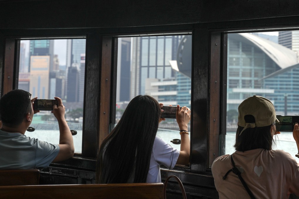 Tourists on the Star Ferry take photos of Victoria Harbour on February 24. Photo: Eugene Lee