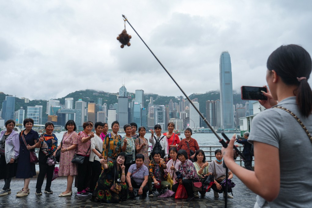 Visitors pose for a photo in Tsim Sha Tsui. Authorities have said there may be last-minute changes to a Victoria Harbour fireworks display on May 1. Photo: Sam Tsang