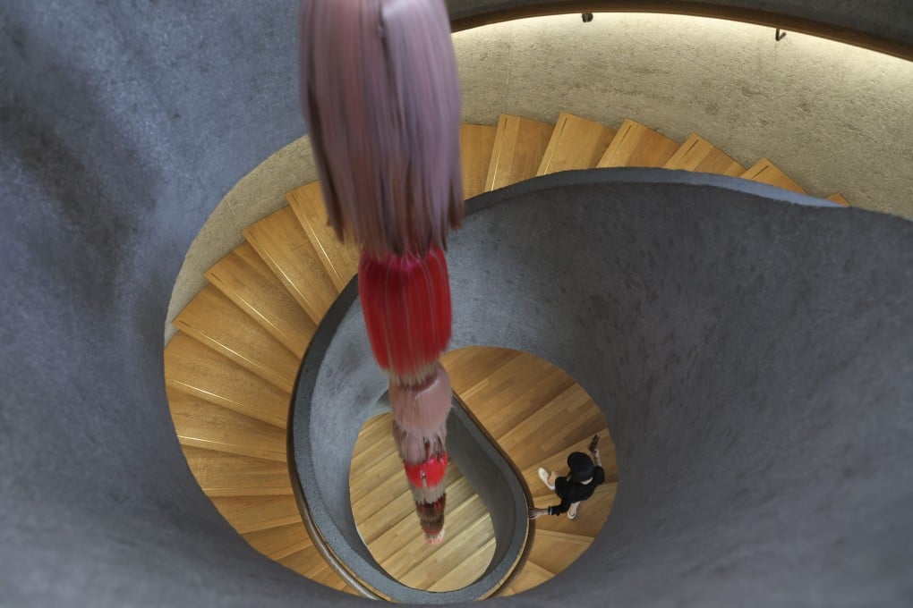 A visitor poses for a picture on a circular staircase at Tai Kwun heritage arts centre in Central, Hong Kong, one of several striking sets of stairs in the city. Photo: Yik Yeung-man