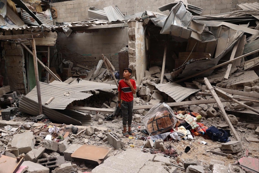 A Palestinian child stands near objects salvaged amid the debris of a house destroyed by Israeli bombardment in Rafah in the southern Gaza Strip. Photo: AFP