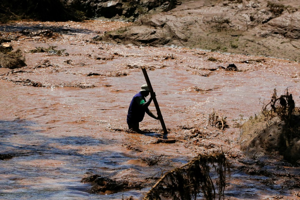 A man uses a stick to cross a river after heavy flash floods wiped out several homes when a dam burst, following heavy rains in Kenya on Monday. Photo: Reuters