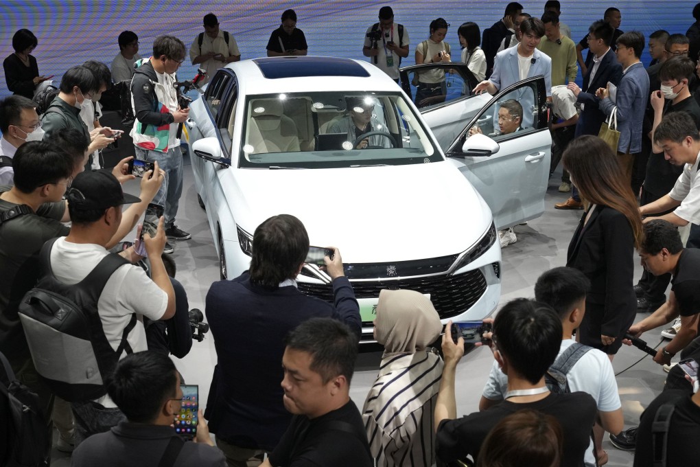 Visitors take a closer look at BYD’s new plug-in hybrid model at the Beijing International Automotive Exhibition on April 25. Photo: Kyodo