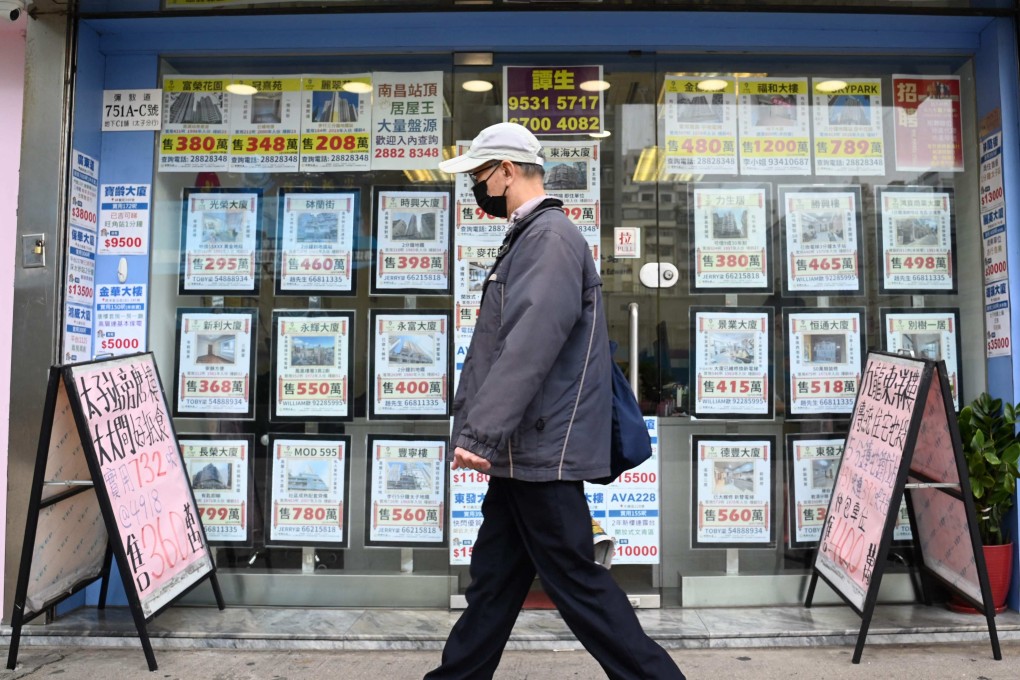 A pedestrian walks past a property agency in Hong Kong. Property prices in the city rose for the first time in 11 months in March. Photo: AFP