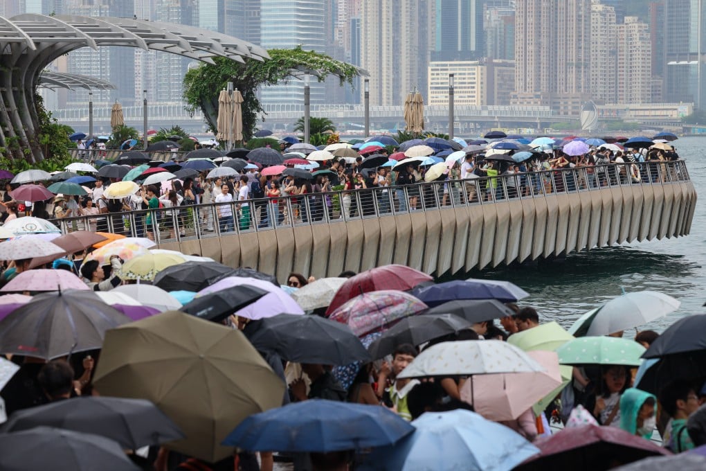 Visitors flock to the promenade overlooking Victoria Harbour in Tsim Sha Tsui despite rainy and cloudy conditions. Photo: Jelly Tse