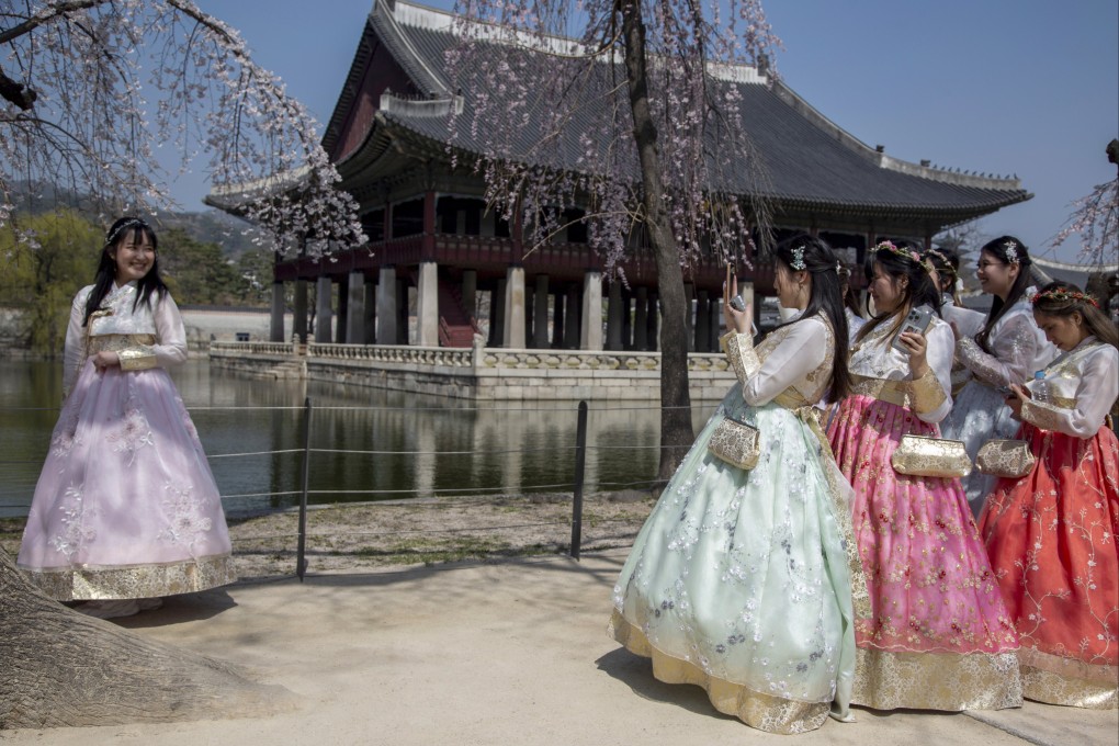 Tourists wearing Hanbok, a Korean traditional dress, take pictures at the Gyeongbokgung Palace in Seoul. Photo: EPA-EFE