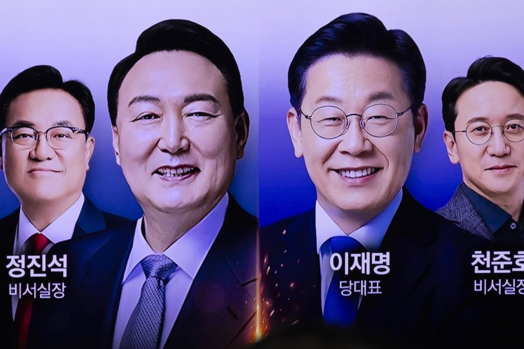A news report about South Korean President Yoon Suk-yeol (centre, left) first-ever meeting with opposition leader Lee Jae-myung (centre, right) is seen on a television screen at a railway station in Seoul on Monday. Photo: EPA-EFE
