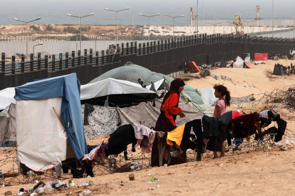 Displaced Palestinians sit outside to escape the searing heat in their camp tents in Rafah. Photo: AFP