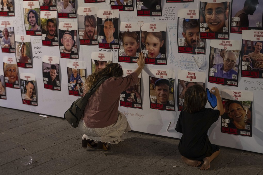A woman in Tel Aviv touches photos of Israelis missing and held captive in Gaza after the Hamas attack in October. Photo: AP