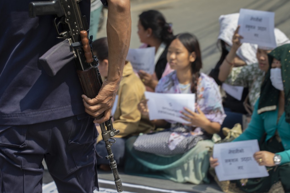 A security official looks on as family members of Nepalis who joined the Russian army stage a sit-in protest, in Kathmandu, urging their relatives’ safe return to Nepal. Photo: EPA-EFE