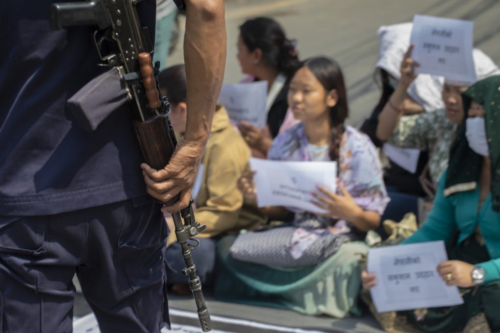 A security official looks on as family members of Nepalis who joined the Russian army stage a sit-in protest, in Kathmandu, urging their relatives’ safe return to Nepal. Photo: EPA-EFE