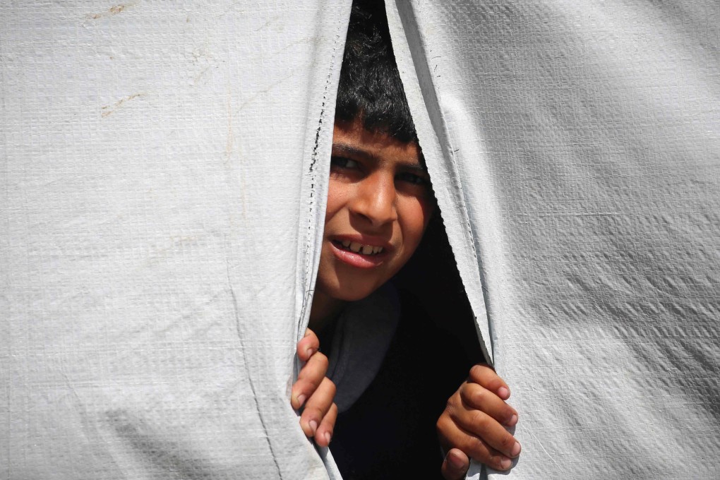A displaced Palestinian boy looks out of a tent in Rafah in the southern Gaza Strip as people prepare to leave following an evacuation order by the Israeli army on Monday. Photo: AFP