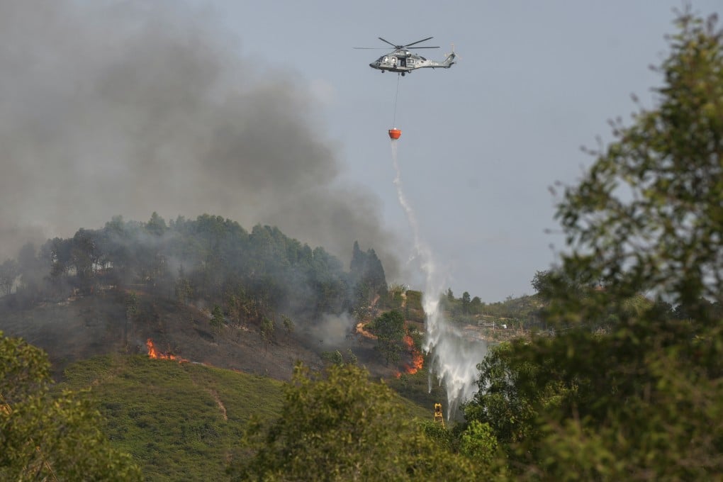 A Government Flying Service helicopter drops water on a hill fire in Yuen Long in March. Photo: Sam Tsang
