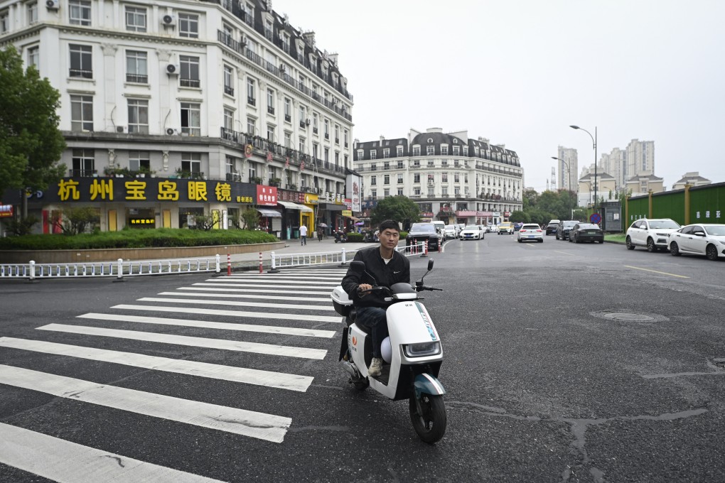 A man riding his electric bicycle on a street near a residential area modelled on Paris in Hangzhou. Photo; AFP