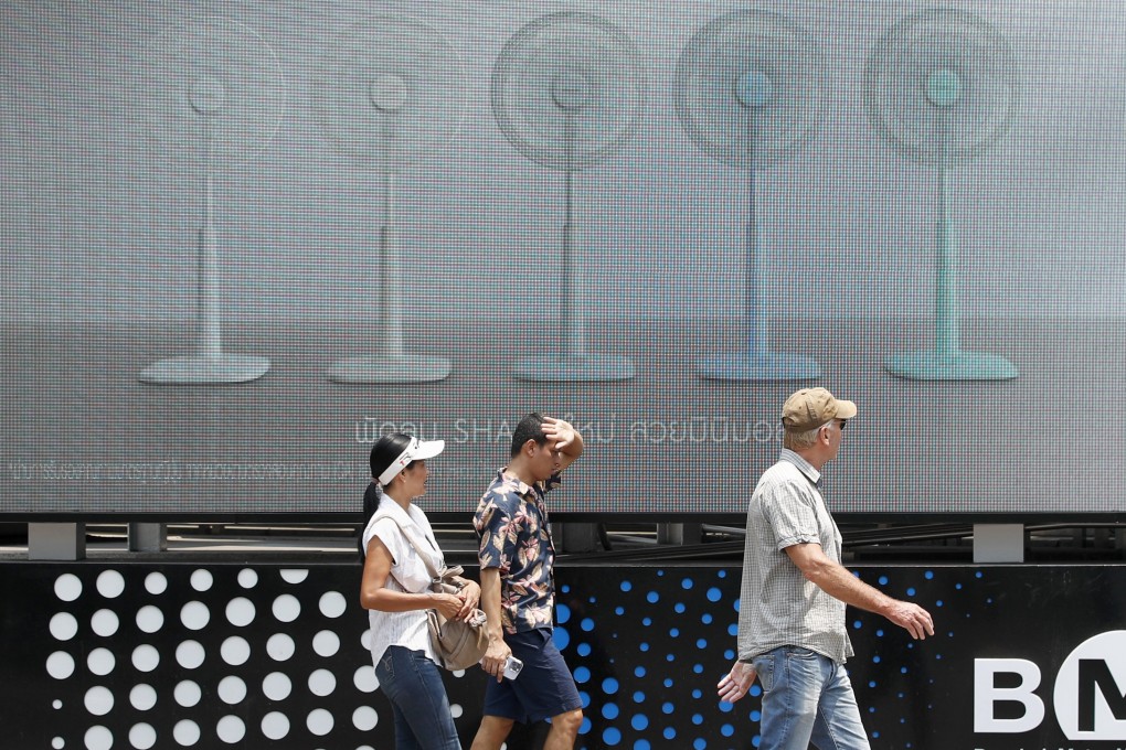 Pedestrians walk past an electric fan advertisement during hot weather in Bangkok, Thailand, 01 May 2024. Thailand is facing a severe heatwave, with temperatures soaring to record highs of over 44 degrees Celsius in some areas. Photo: EPA-EFE