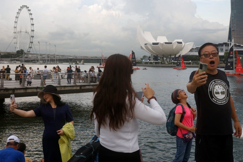 Chinese tourists take selfies at Marina Bay in Singapore. Photo: Reuters