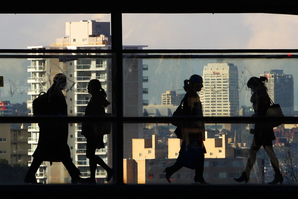 Peak-hour commuters walk across a glass walled bridge between office buildings in Sydney. Flexible working practices are having a moment post-pandemic, not only in the Asia-Pacific but around the world. Photo: Reuters