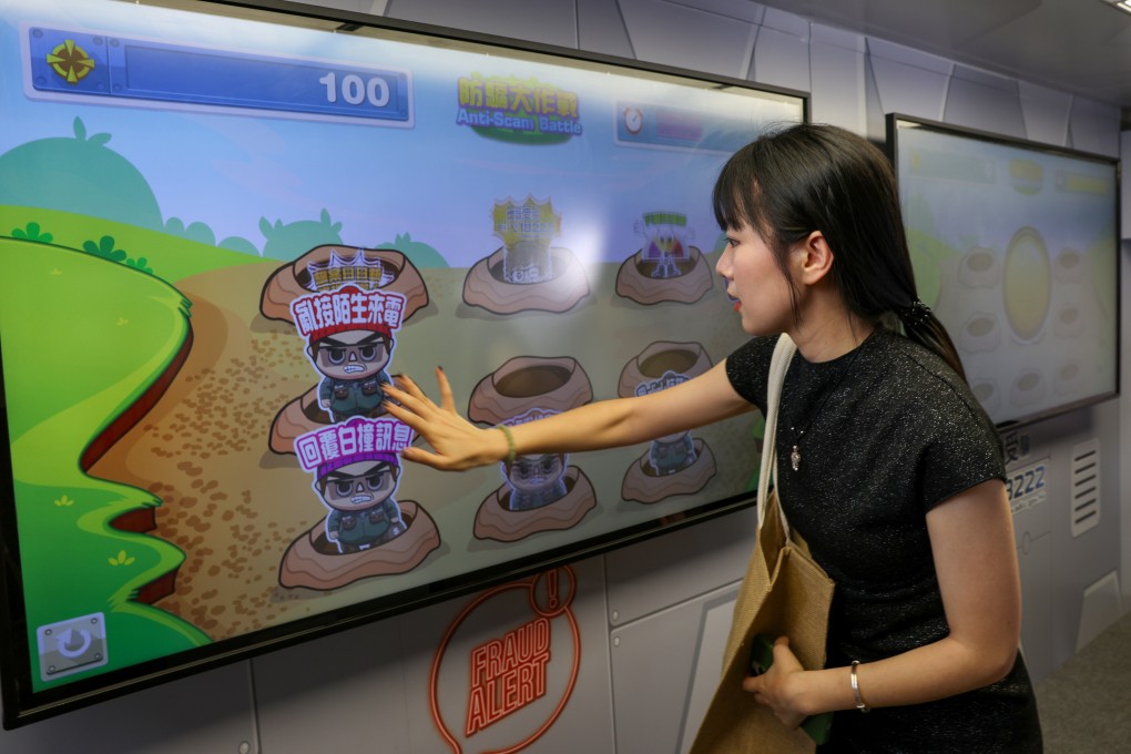 A tourist from mainland China plays an anti-scam game at a police publicity vehicle. Photo: Yik Yeung-man