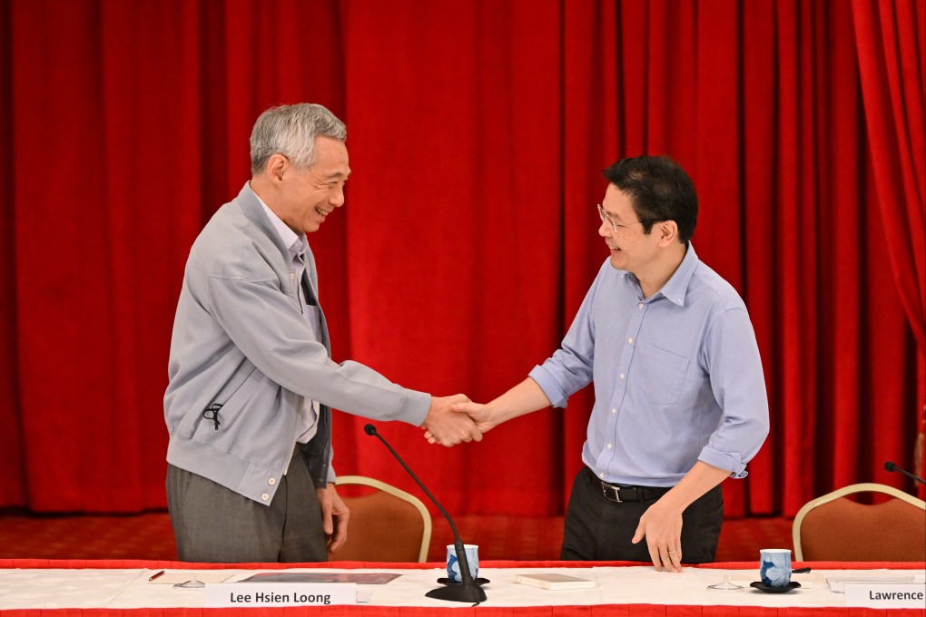 Singapore Prime Minister Lee Hsien Loong shakes hands with Finance Minister Lawrence Wong during a news conference in 2022. Photo: The Straits Times via Reuters