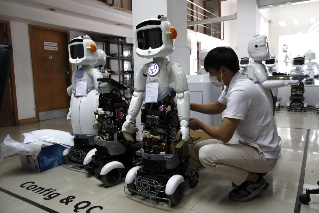 A Thai technician sets up robots designed for healthcare and service businesses at CT Asia Robotics in Bangkok on July 24, 2023. Across Asia, demand for digital infrastructure will only intensify in sectors ranging from generative AI to e-healthcare. But soft infrastructure gaps will also need to be addressed to help workers thrive in a digitised economy. Photo: EPA-EFE