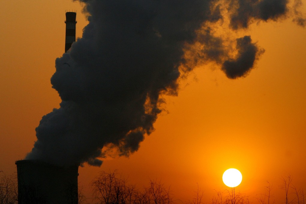 The sun sets next to a smokestack from a coal-burning power station in Beijing. Photo: Reuters