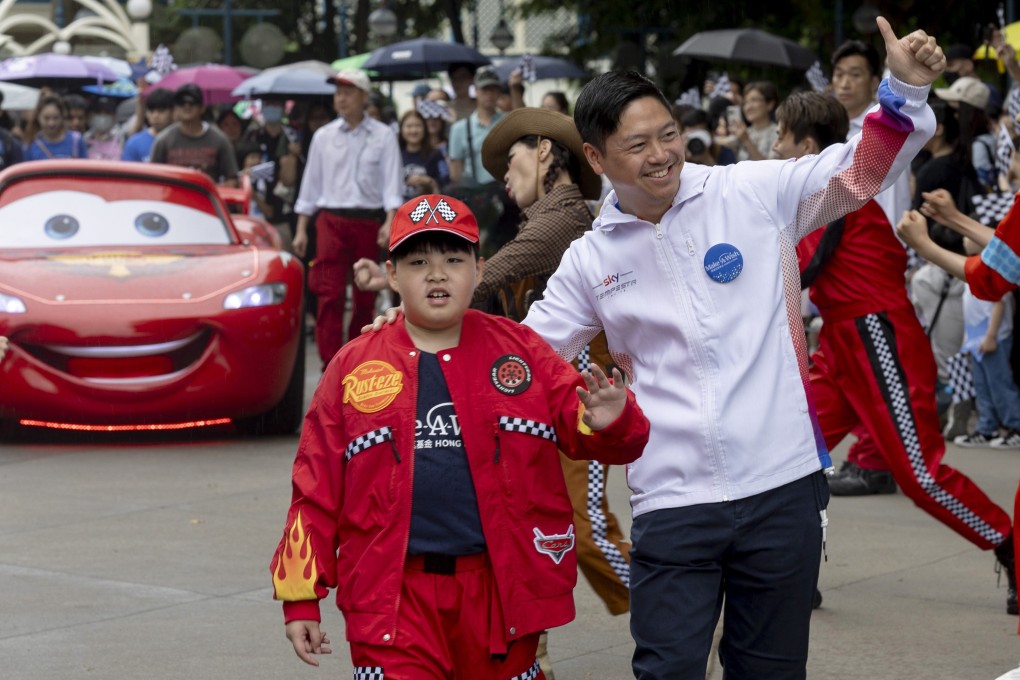 Wish child Heison Leong (left) was accompanied by Hong Kong racing driver Jonathan Hui and Disney character Lightning McQueen during a special parade at Hong Kong Disneyland Resort held in collaboration with Make-A-Wish Hong Kong to commemorate World Wish Day.