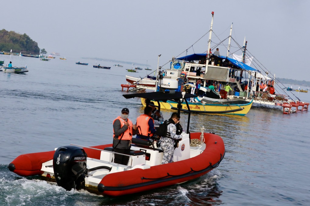 Philippine coastguard personnel on a rubber boat escort Filipino fishermen aboard their vessels sailing towards Scarborough Shoal in Zambales province on May 15. Photo: EPA-EFE