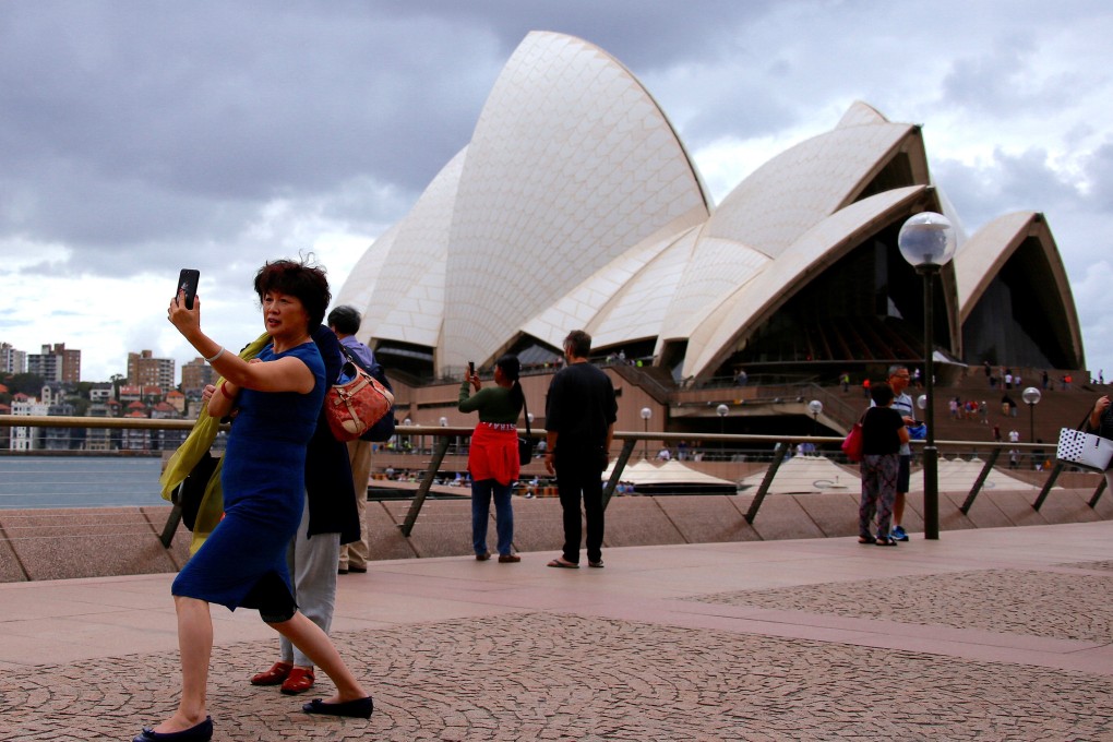 A Chinese tourist takes a selfie in front of the Sydney Opera House in Australia. Photo: Reuters