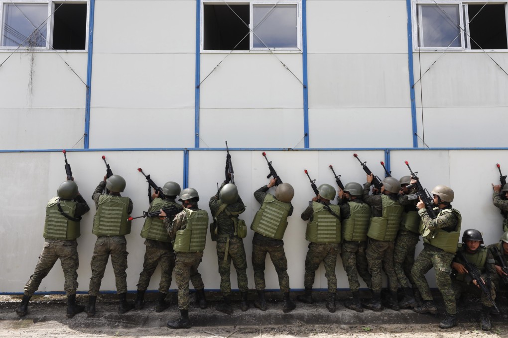 Soldiers of the Armed Forces of the Philippines take cover beside a wall during an assault exercise at Fort Magsaysay military camp north of Manila. Photo: EPA-EFE