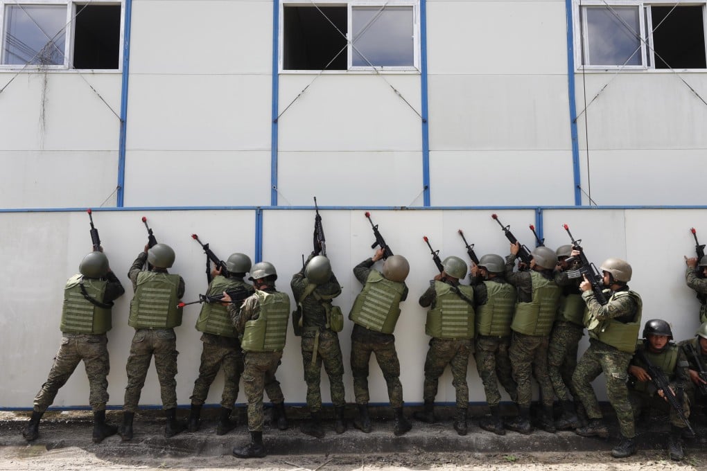 Soldiers of the Armed Forces of the Philippines take cover beside a wall during an assault exercise at Fort Magsaysay military camp north of Manila. Photo: EPA-EFE
