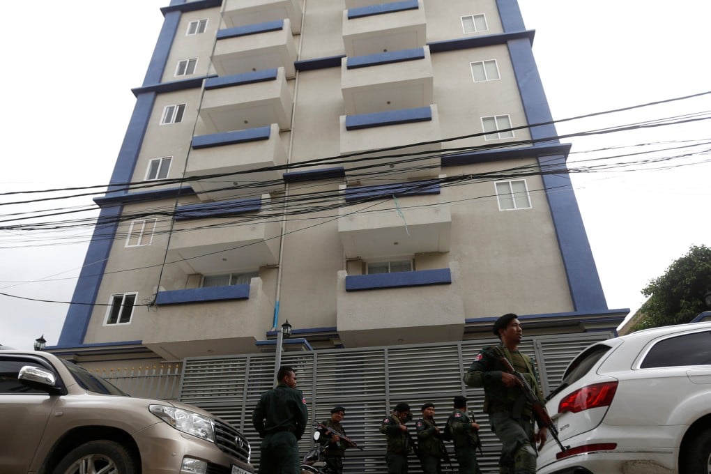 Cambodia police stand guard at a scam centre where they arrested dozens of foreign nationals during a raid in Phnom Penh. Photo: Reuters
