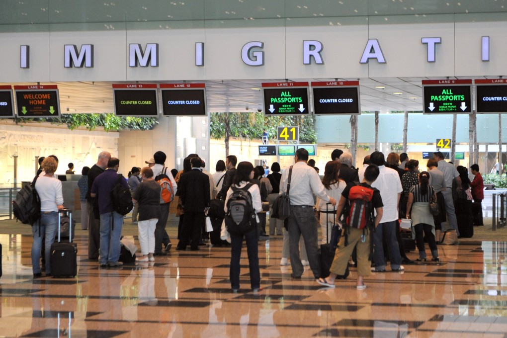 Visitors queing at the immigration counter after passing through health screening at the Changi International Airport in Singapore. Photo: AFP