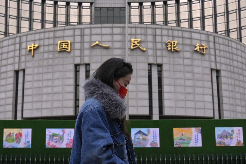 A pedestrian walks by the People’s Bank of China in Beijing on February 20. Amid US dollar strength, China might be tempted to devalue the yuan to improve competitiveness versus the yen and the won. Photo: AP