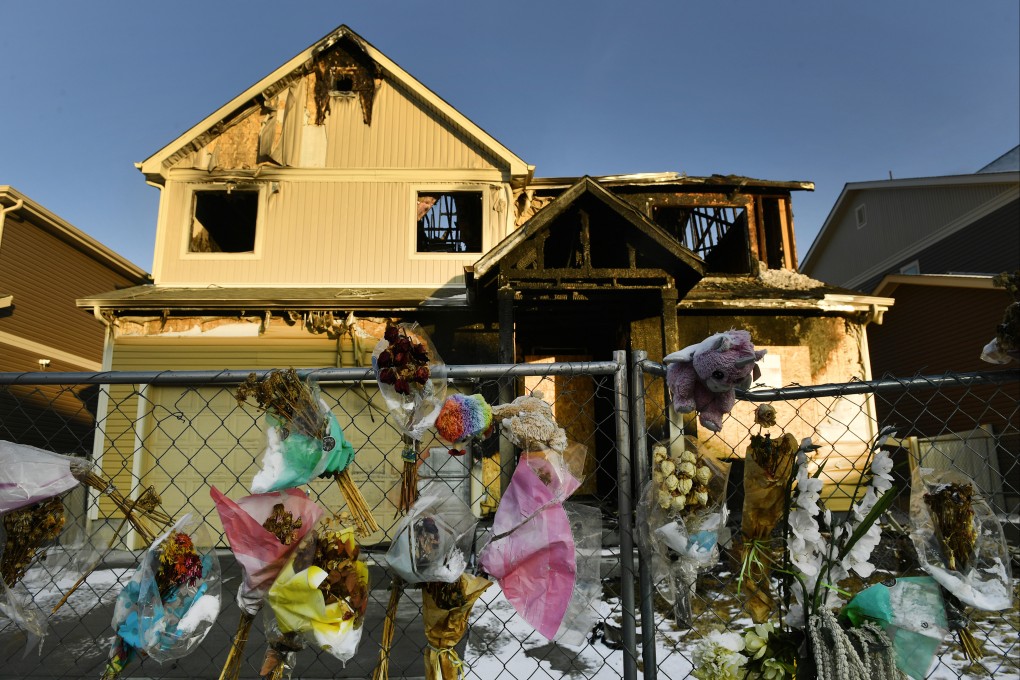 The home of the Diol family is seen with bouquets, stuffed animals and other items hanging on the fence in January 2021. Photo: Denver Post via AP