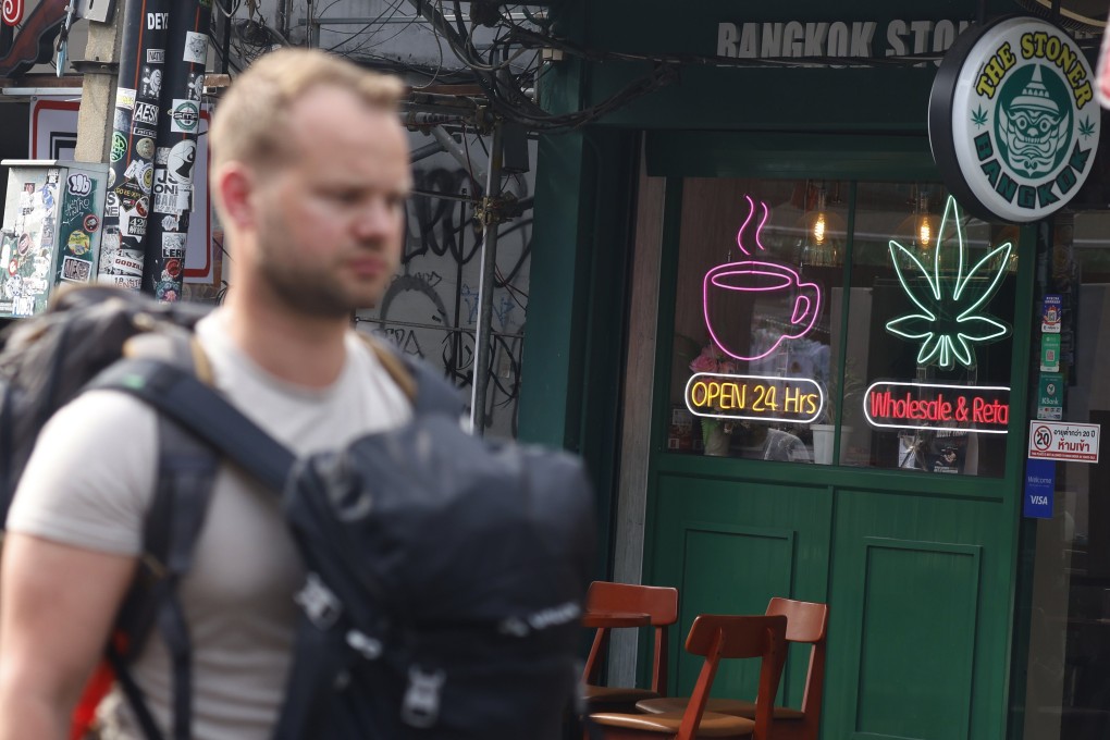 A foreign tourist walks past a cannabis shop in Bangkok, Thailand, earlier this month. Photo: EPA-EFE