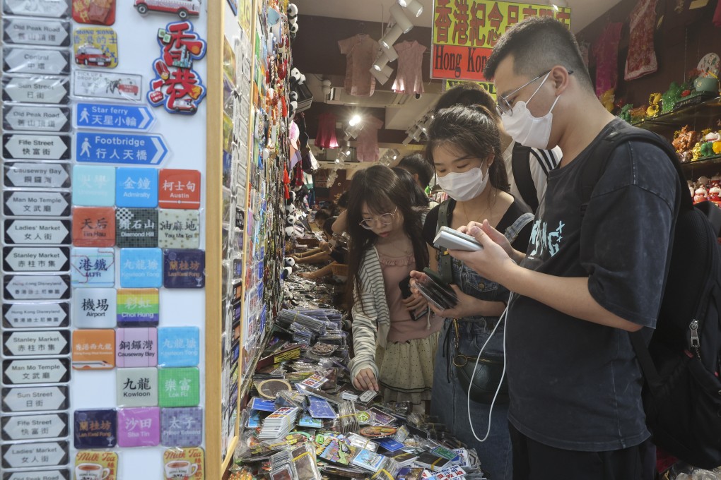 Tourists buy souvenirs in Tsim Sha Tsui. The city’s tourism sector could feel the impact of reduced spending by overnight visitors, according to a government forecast. Photo: Edmond So