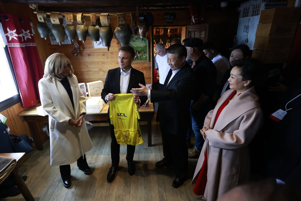 Chinese President Xi Jinping and his wife Peng Liyuan talk to French President Emmanuel Macron, holding a Tour de France cycling race jersey next to his wife Brigitte Macron in a restaurant at the Tourmalet Pass in the Pyrenees moutains. Photo: EPA-EFE