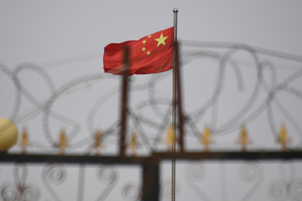 The Chinese flag behind razor wire at a housing compound in Yangisar, south of Kashgar, in China’s western Xinjiang region.. PhotoL AFP/Badung Police
