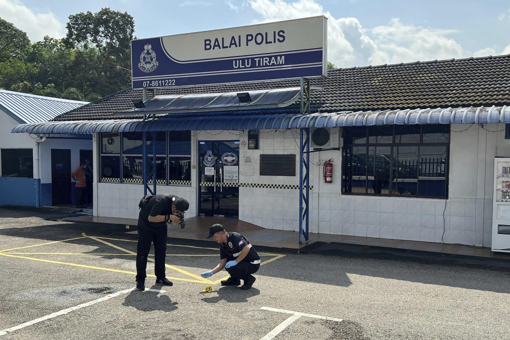 A police forensic team takes a picture outside of the police station in Ulu Tiram where Friday’s attack took place. Photo: AP