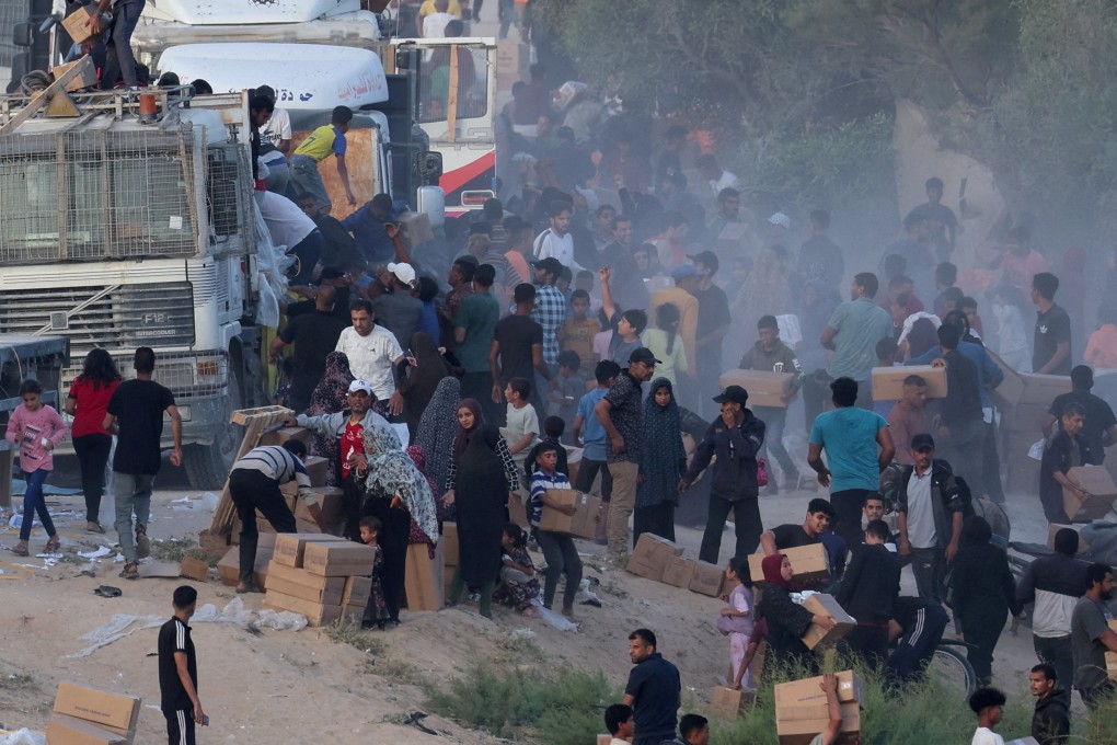 Palestinians climb onto trucks to grab aid that was delivered into Gaza through a US-built pier on Saturday. Photo: Reuters