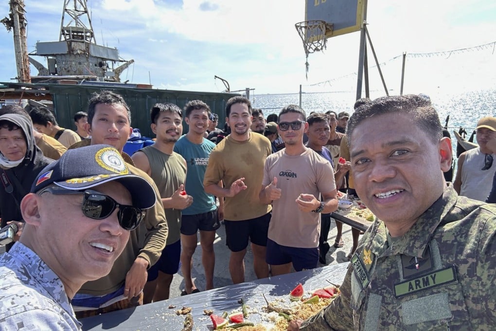 Philippine military chief Romeo Brawner Jnr (right) and Vice-Admiral Alberto Carlos (left) share a meal with Filipino marines and navy personnel stationed aboard the long-marooned BRP Sierra Madre at the Second Thomas Shoal in December 2023. Photo: Armed Forces of the Philippines PAO via AP