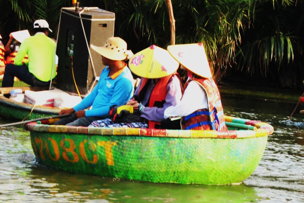 Tourists on traditional basket boats on the Thu Bon river blast music from a mobile sound system. Photo: Tom Fawthrop