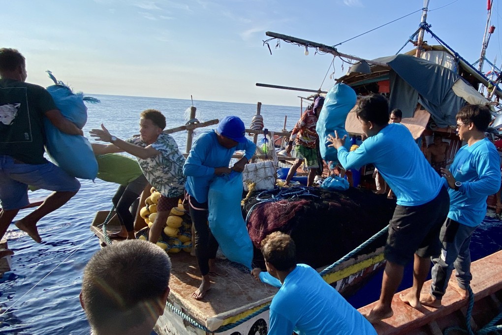 Filipino fishermen receiving supplies from volunteers near Scarborough Shoal in the disputed South China Sea. Photo: EPA-EFE