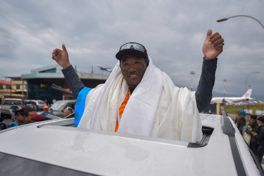 Nepali guide Kami Rita Sherpa gestures to the crowd upon arriving at the Tribhuvan airport in Kathmandu on May 25 last year. Photo: AFP