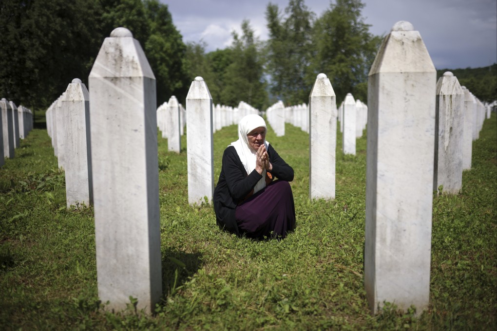 A woman mourns next to the graves of her two sons, victims of the Srebrenica genocide, at the Memorial Centre in Potocari, Bosnia. Photo: AP