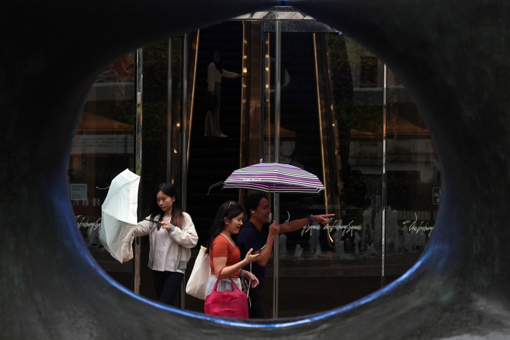 Pedestrians walk past Exchange Sqaure in Central under rainy and gusty conditions. Photo: Eugene Lee