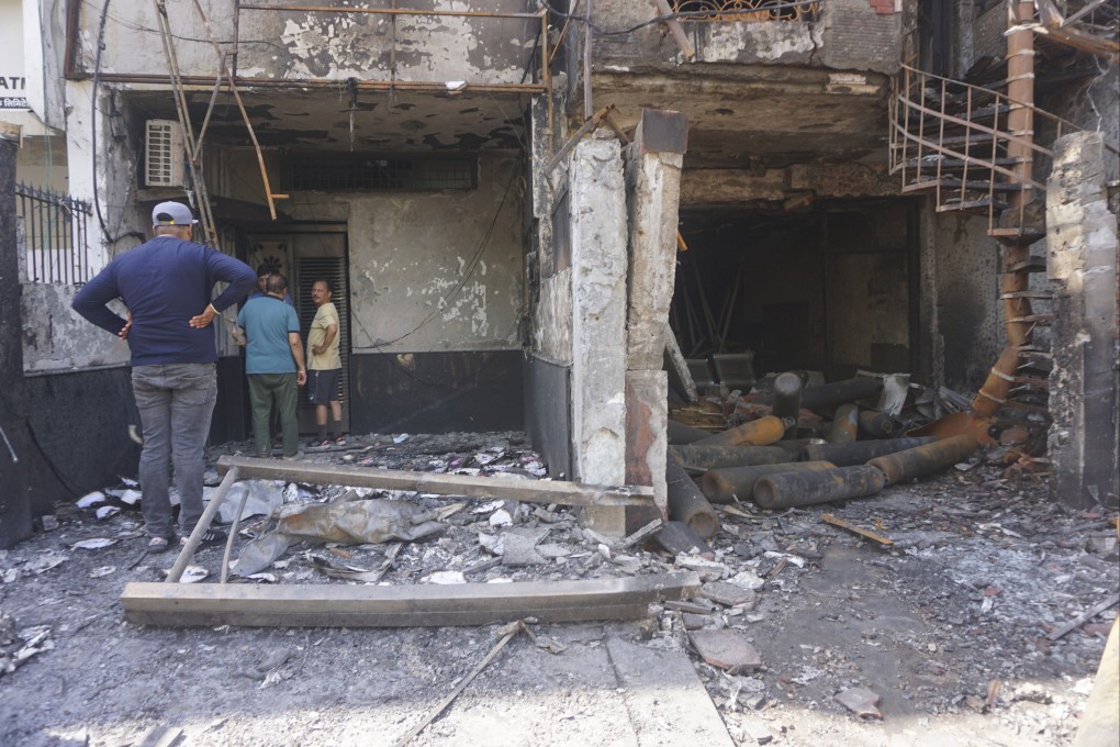 People look at the burnt building of a baby care center in New Delhi, India on Sunday. Photo: Photo
