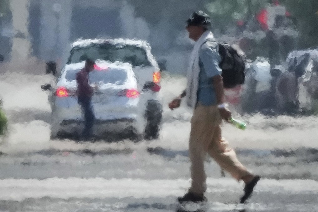 A person crosses a street in the afternoon heat on Saturday in Downtown Houston. Photo: AP