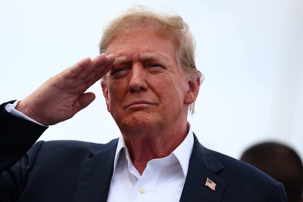 Donald Trump salutes at the NASCAR Coca-Cola 600 auto race in Concord, North Carolina on Sunday. Photo: AFP